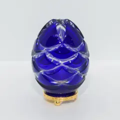 Uovo blu di cristallo intagliato, ispirato agli originali uova Fabergé, su base dorata.