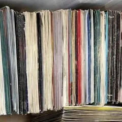 Una collezione di dischi in vinile che valgono una fortuna, con copertine colorate e bianche, impilati in modo ordinato.