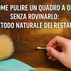 Mano con cotton fioc pulisce un quadro a olio senza vetro, mostrando il metodo naturale dei restauratori per la pulizia.