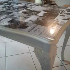 Tavolo antico trasformato con collage di giornali d'epoca sotto resina trasparente: un modo moderno per dare nuova vita ai mobili.