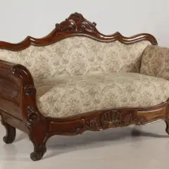 Divano in legno intagliato, stile Luigi Filippo, con seduta e schienale imbottiti in tessuto floreale.
