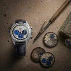 Orologio Zenith El Primero con quadrante bianco e blu, cinturino in pelle blu, circondato da quadranti di ricambio e strumenti da orologiaio.
