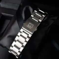 Chiusura di un bracciale per orologio in metallo, con logo GS inciso, pronto per essere indossato.