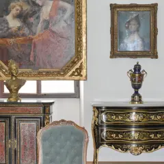 Antiquariato di lusso: un busto dorato su un mobile intarsiato, un vaso decorato e dipinti d'epoca. Un'ispirazione per chi vuole diventare antiquario.