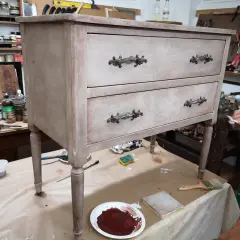 Un mobile antico in fase di restauro in stile shabby. Pennelli, colori e materiali pronti per trasformare un vecchio mobile.