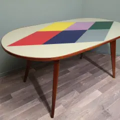 Tavolino anni '70 con piano ovale decorato a rombi colorati. Un esempio di come rinnovare mobili anni 70 con stile.