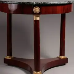 Tavolino rotondo in mogano con piano in marmo, gambe a clessidra e dettagli dorati, in perfetto stile direttorio.