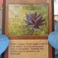 Il Black Lotus, una delle carte più costose di Magic, tenuta con guanti blu.