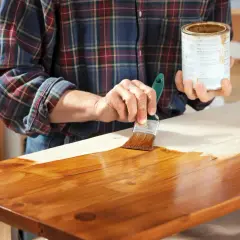 Applicazione di impregnante su legno, mostrando la differenza tra impregnante e vernice.