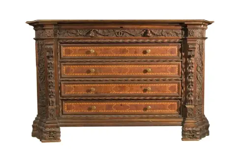 Antico canterano intarsiato con decorazioni scultoree, un vero pezzo d'antiquariato che evoca il suo significato storico.