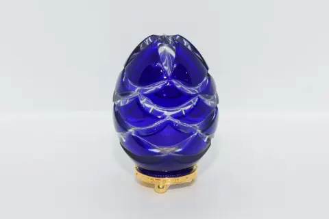 Uovo blu di cristallo intagliato, ispirato agli originali uova Fabergé, su base dorata.