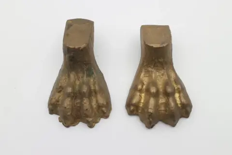 Due elementi in bronzo a forma di zampa di leone, tipici dell'epoca dei mobili con questo dettaglio.