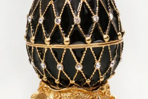 Uova Fabergé perdute: un prezioso scrigno nero con decorazioni dorate e cristalli, che evoca mistero e tesori nascosti.