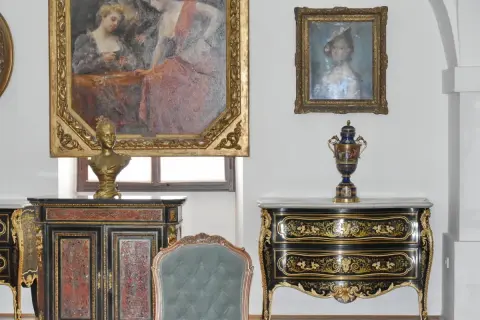 Antiquariato di lusso: un busto dorato su un mobile intarsiato, un vaso decorato e dipinti d'epoca. Un'ispirazione per chi vuole diventare antiquario.