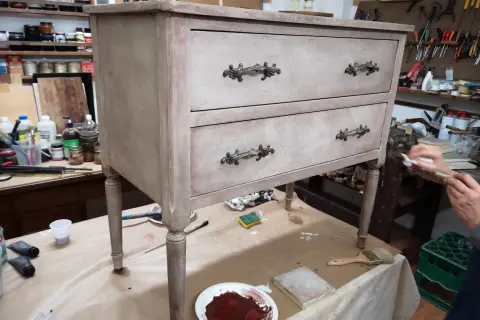 Un mobile antico in fase di restauro in stile shabby. Pennelli, colori e materiali pronti per trasformare un vecchio mobile.
