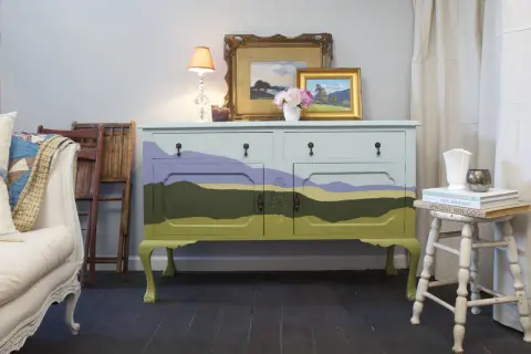 Mobile antico dipinto con paesaggio stilizzato, un'idea per mobili antichi colorati che porta un tocco di natura in casa.