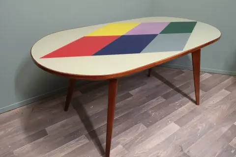 Tavolino anni '70 con piano ovale decorato a rombi colorati. Un esempio di come rinnovare mobili anni 70 con stile.