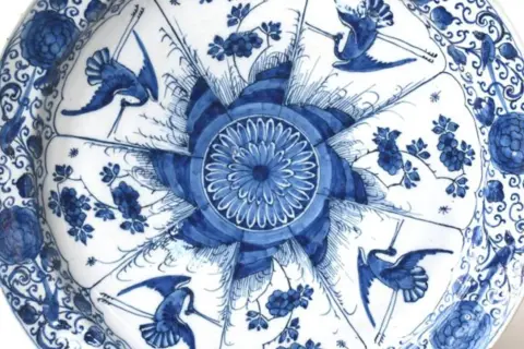 Piatto in ceramiche di Delft blu e bianche con gru e fiori.