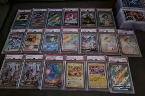 A collection of graded Pokémon cards, including Charizard, Mewtwo, and Pikachu, displayed in protective cases.
