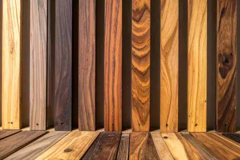 Diverse assi di legno, da chiare a scure, mostrano venature naturali. Alcune sembrano pronte per scurire il legno, altre sono già scure.
