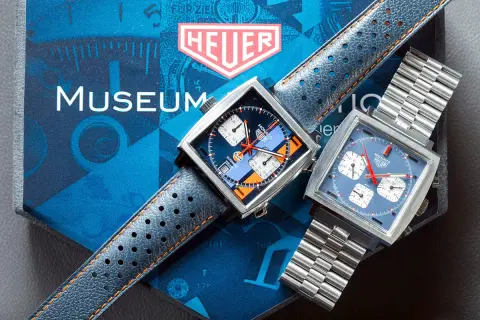 Due orologi Heuer Monaco, uno con quadrante blu e arancione Gulf, l'altro blu, ricordano lo stile di Steve McQueen.