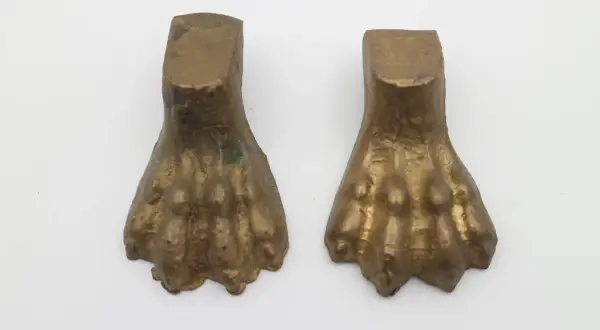 Due elementi in bronzo a forma di zampa di leone, tipici dell'epoca dei mobili con questo dettaglio.