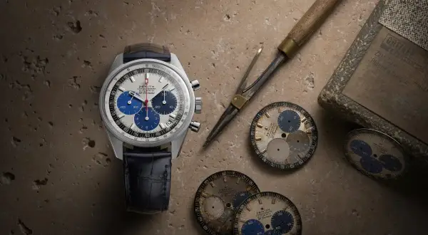 Orologio Zenith El Primero con quadrante bianco e blu, cinturino in pelle blu, circondato da quadranti di ricambio e strumenti da orologiaio.