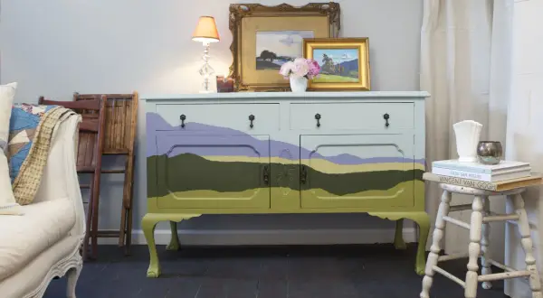 Mobile antico dipinto con paesaggio stilizzato, un'idea per mobili antichi colorati che porta un tocco di natura in casa.