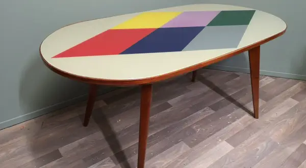 Tavolino anni '70 con piano ovale decorato a rombi colorati. Un esempio di come rinnovare mobili anni 70 con stile.