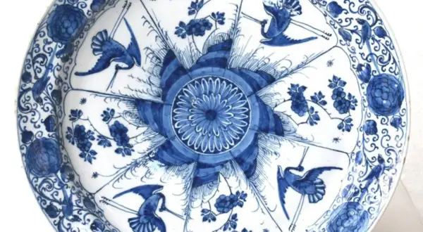 Piatto in ceramiche di Delft blu e bianche con gru e fiori.
