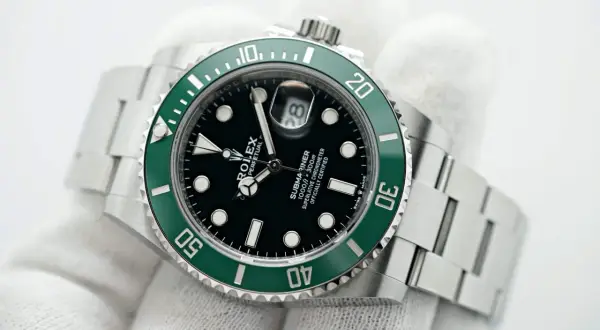 Un Rolex Submariner verde, un confronto tra Hulk e Kermit. L'iconico quadrante nero e la lunetta verde smeraldo brillano.