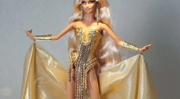 Barbie con abito dorato scintillante, bracciali e orecchini. Potrebbe essere la barbie più costosa al mondo, un vero tesoro.