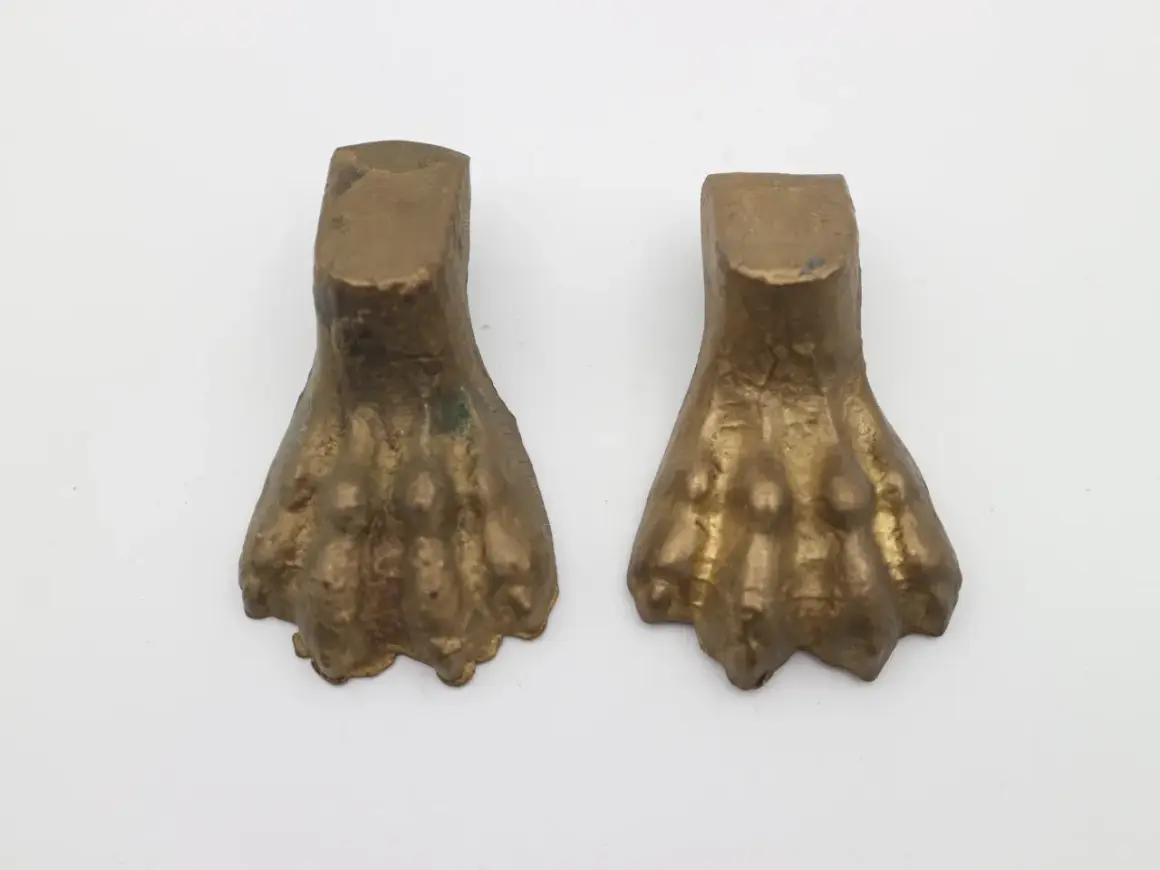 Due elementi in bronzo a forma di zampa di leone, tipici dell'epoca dei mobili con questo dettaglio.