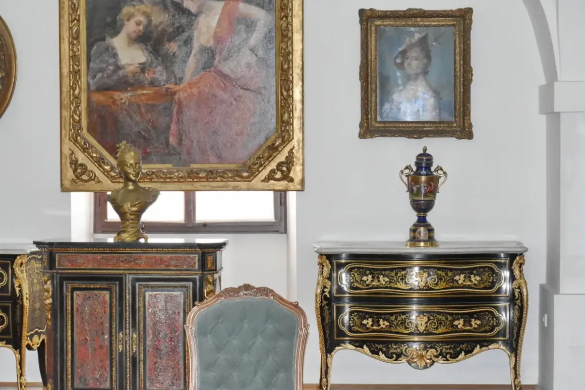 Antiquariato di lusso: un busto dorato su un mobile intarsiato, un vaso decorato e dipinti d'epoca. Un'ispirazione per chi vuole diventare antiquario.