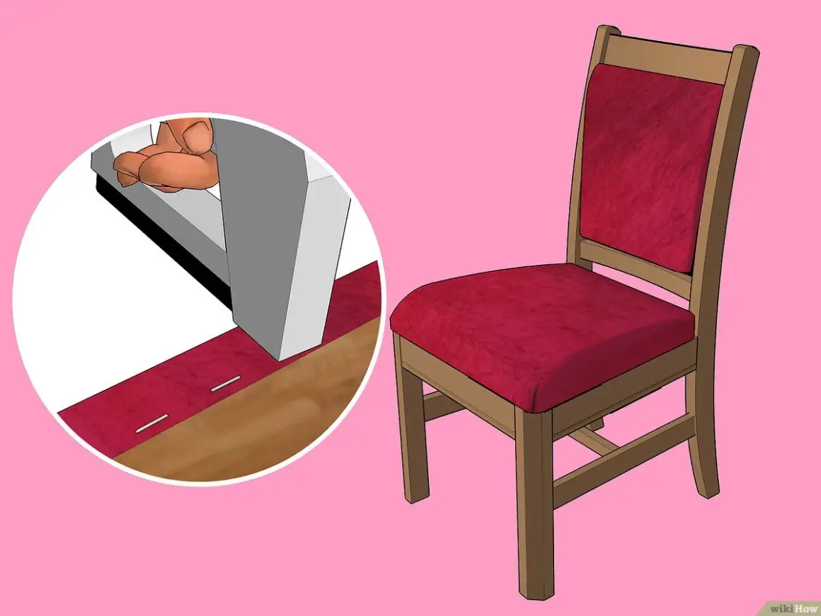 Dettaglio su come imbottire una sedia di legno con tessuto rosso, fissato con graffette.