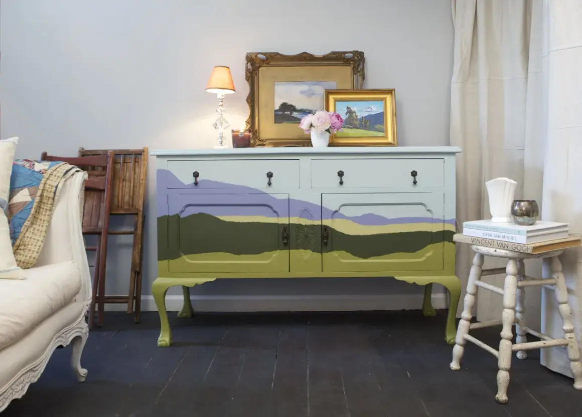 Mobile antico dipinto con paesaggio stilizzato, un'idea per mobili antichi colorati che porta un tocco di natura in casa.