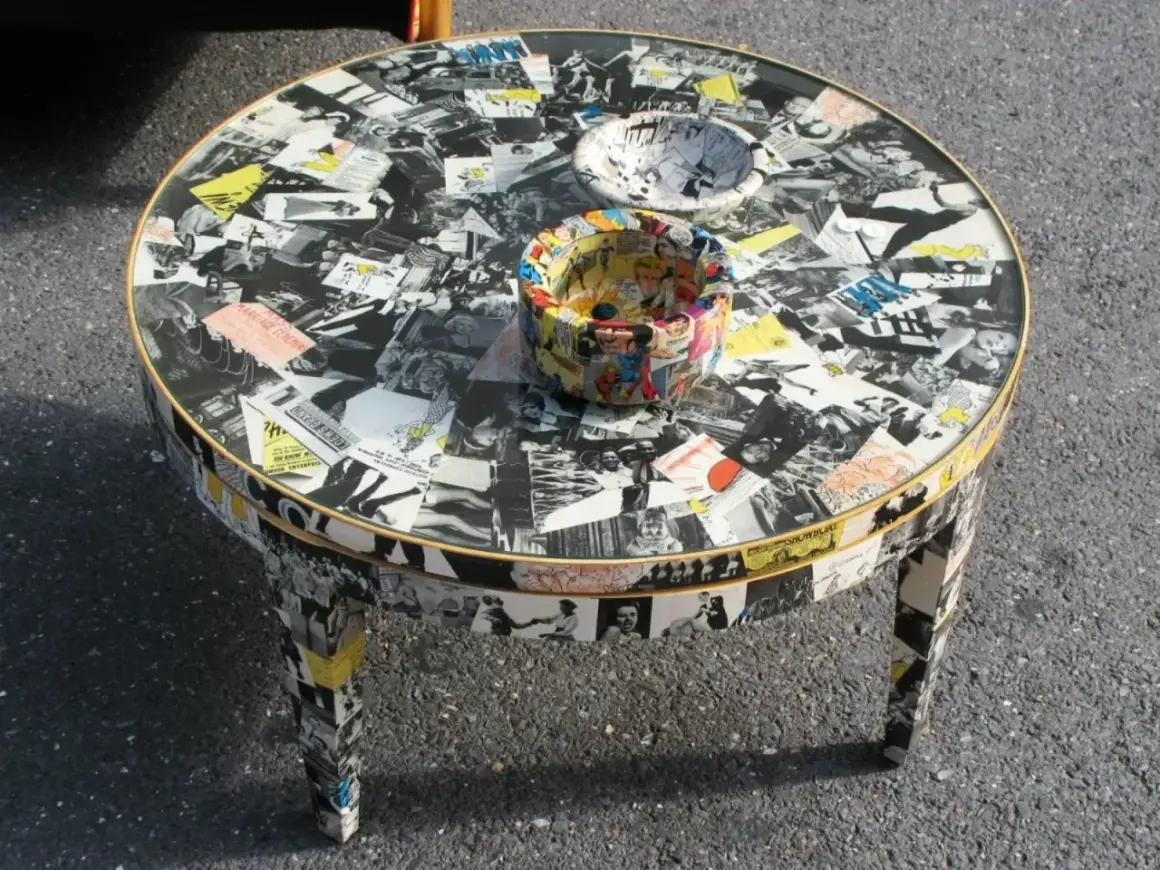 Tavolino rotondo con tecnica decoupage mobili, ricoperto di immagini in bianco e nero e fumetti colorati.