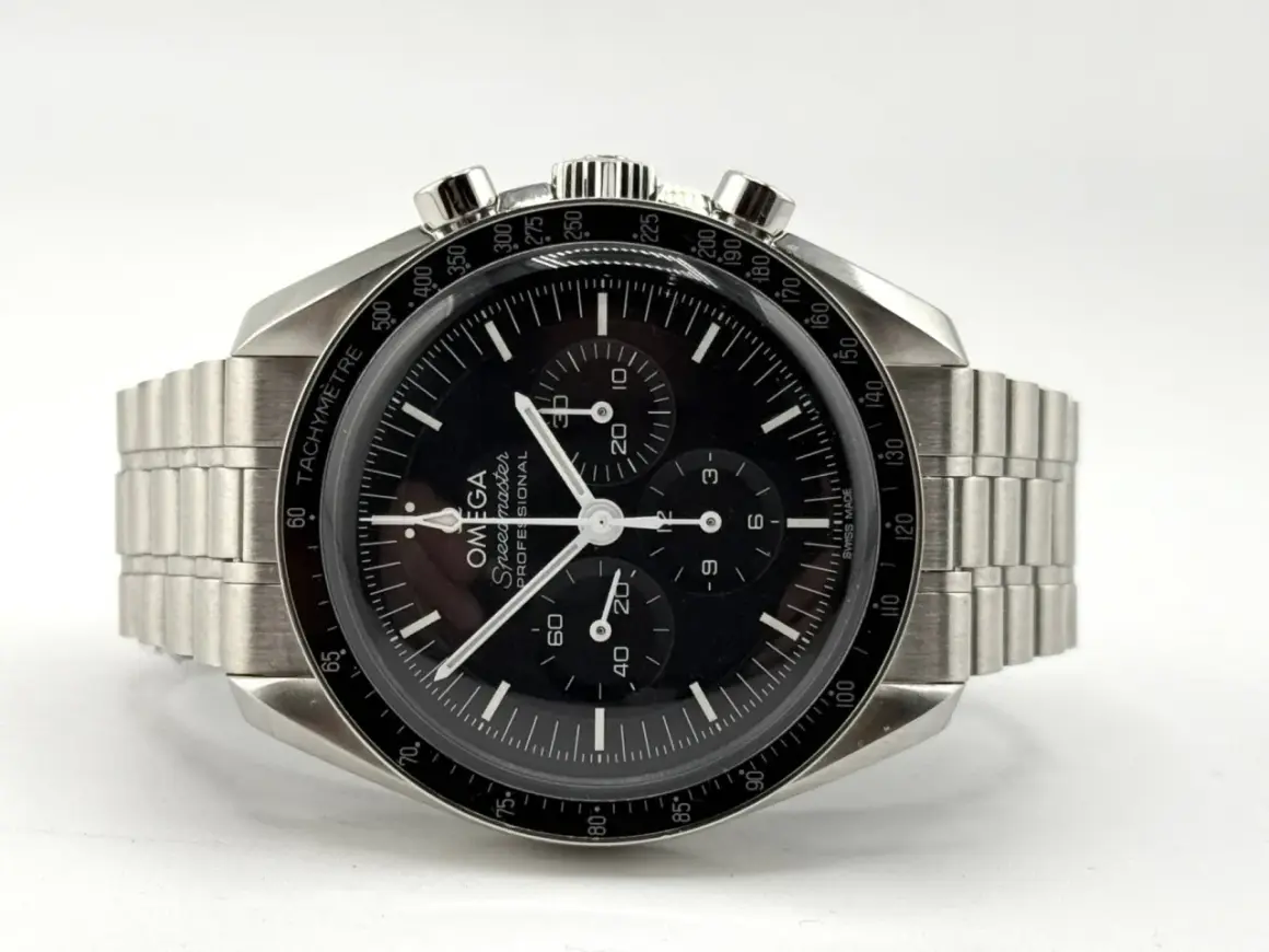 Orologio Omega Speedmaster con quadrante nero e cinturino in metallo, protetto da un **vetro esalite** che cattura la luce.