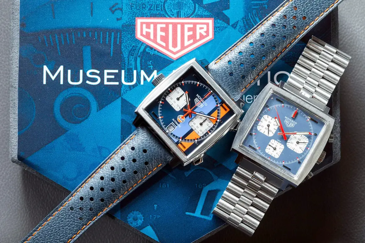 Due orologi Heuer Monaco, uno con quadrante blu e arancione Gulf, l'altro blu, ricordano lo stile di Steve McQueen.