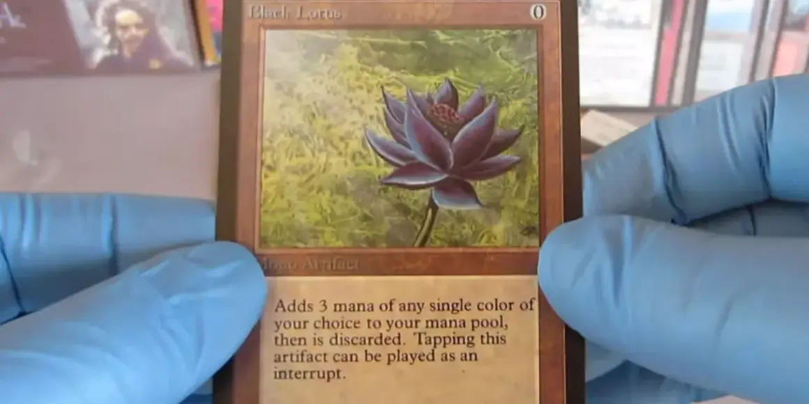 Il Black Lotus, una delle carte più costose di Magic, tenuta con guanti blu.