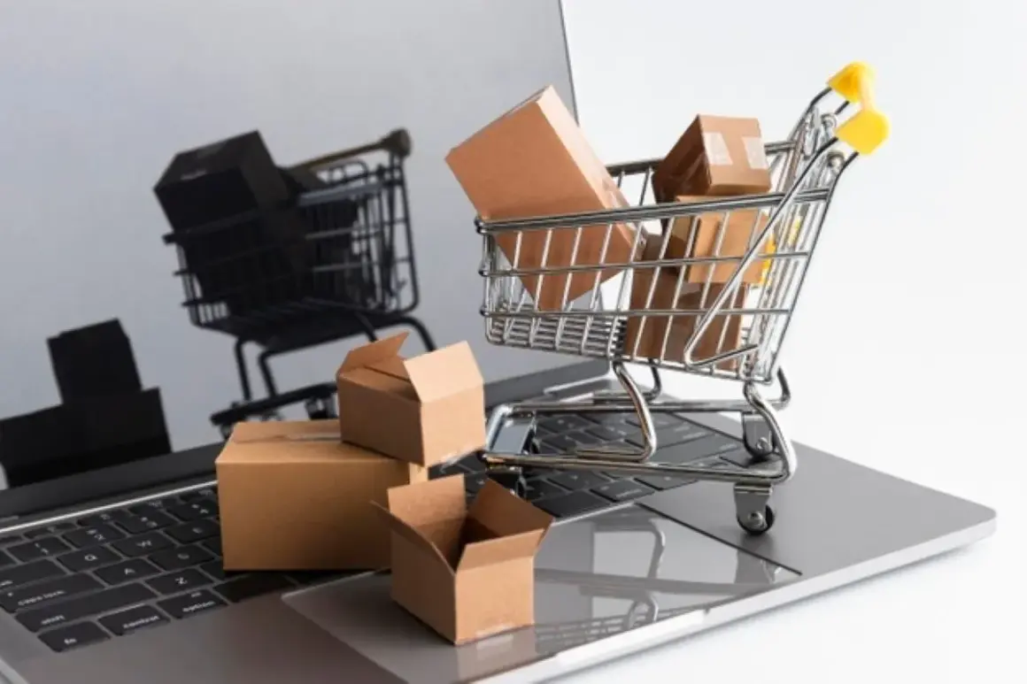 Carrello della spesa pieno di pacchi su un laptop. Il riflesso mostra un altro carrello, suggerendo un'asta online con un prezzo di riserva.