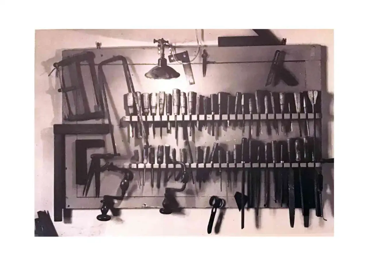 Attrezzi da lavoro disposti su una parete, un invito a scoprire come diventare restauratore con cura e precisione.