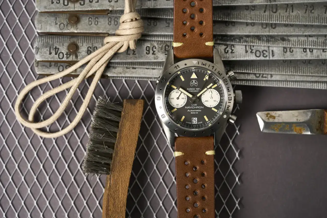 Orologio da polso con cinturino in pelle marrone, strumenti da lavoro e righello. Il suo significato di