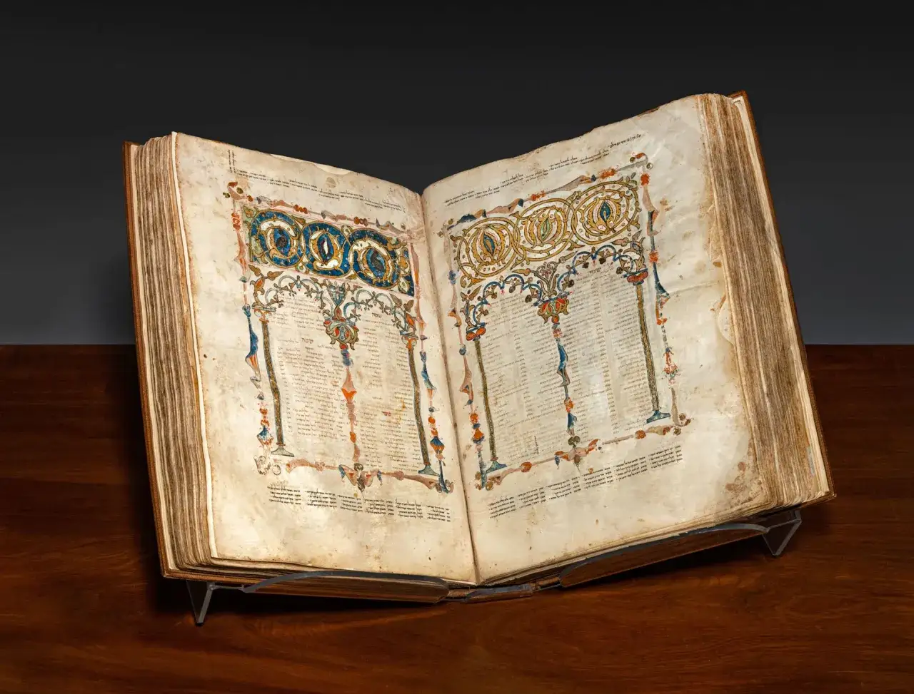 Antico manoscritto ebraico aperto, con decorazioni colorate e testo. Un esempio dei primi libri stampati, testimonianza di un'arte antica.
