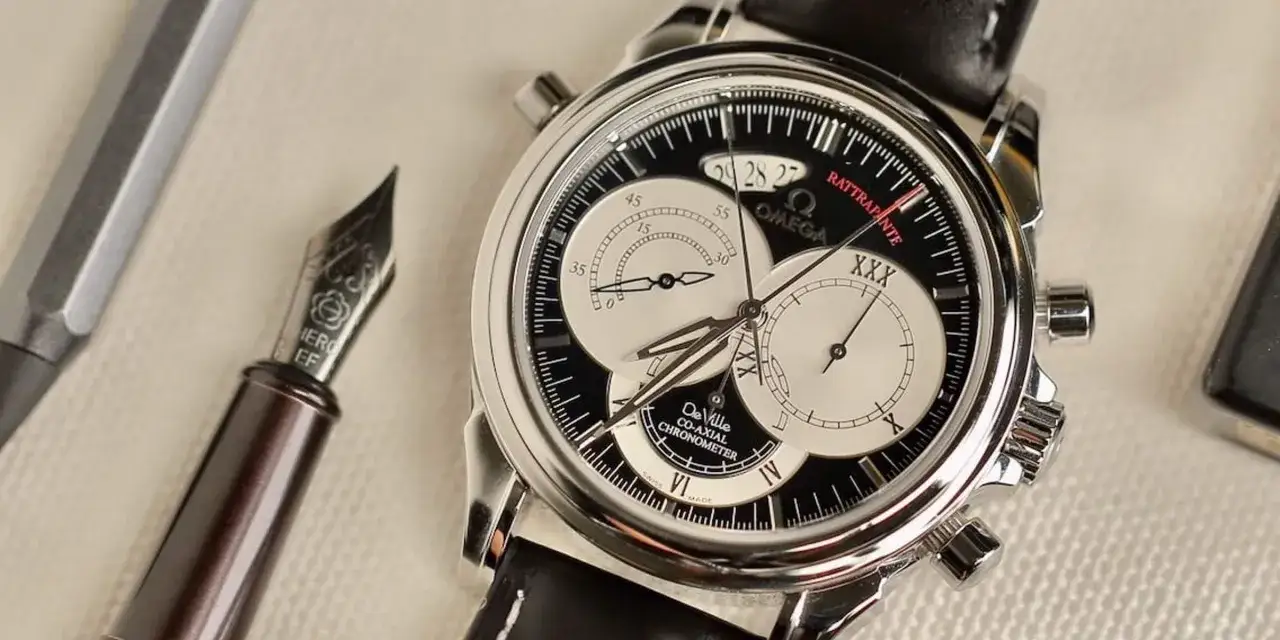 Elegante cronografo rattrapante Omega De Ville Co-Axial, con penna stilografica Hero EF.