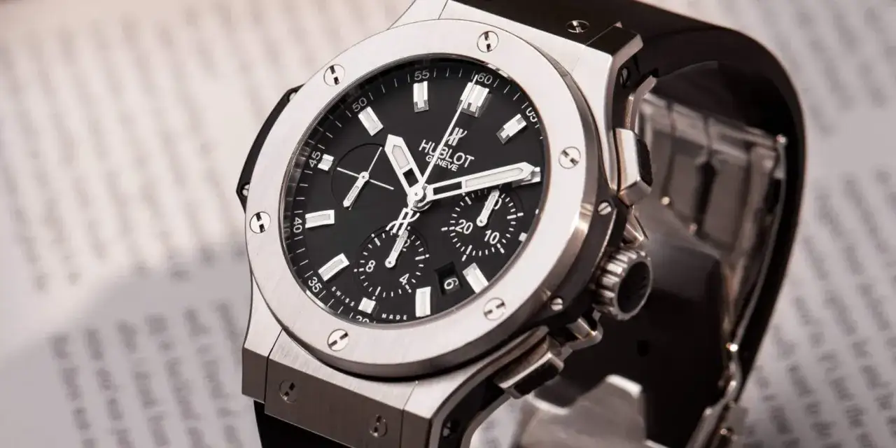 Orologio Hublot più costoso, un cronografo di lusso con quadrante nero e cinturino in gomma, su uno sfondo di testo sfocato.
