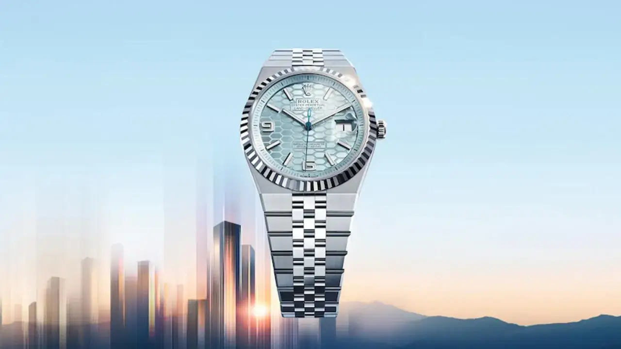 Un Rolex Oyster Perpetual Land-Dweller, con quadrante blu a nido d'ape, fluttua sopra una città futuristica. Un'icona di stile per il 2026.