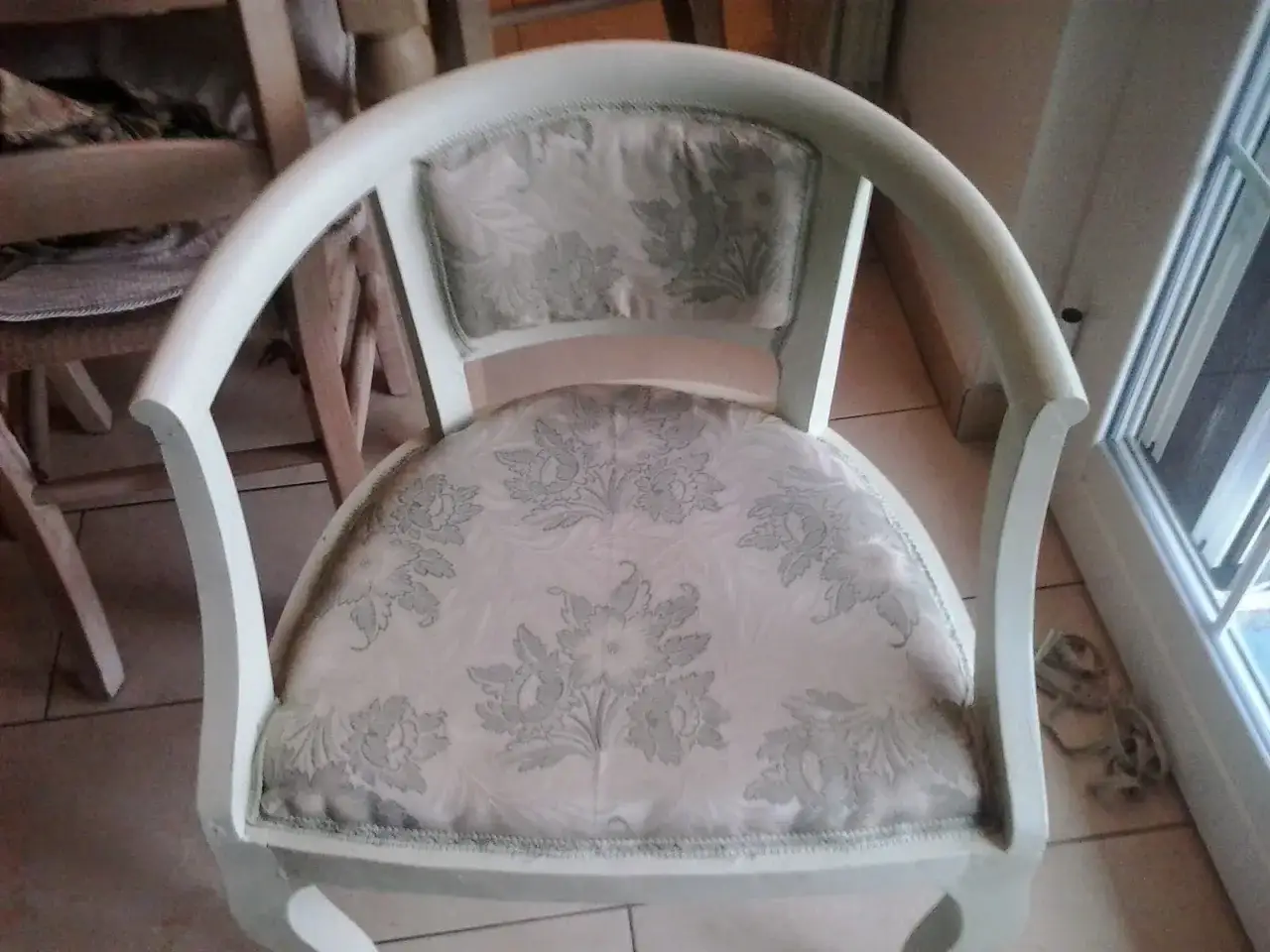 Vecchia poltrona con tessuto floreale chiaro, pronta per essere shabby rimodernata.