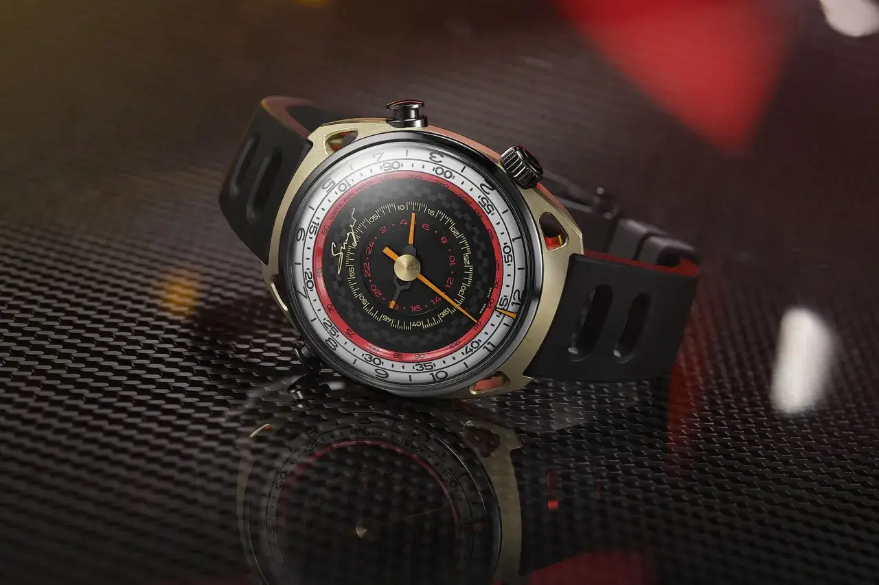Orologio con cassa dorata e cinturino nero, quadrante nero con dettagli rossi e lancette arancioni. Un vero singer reimagined.