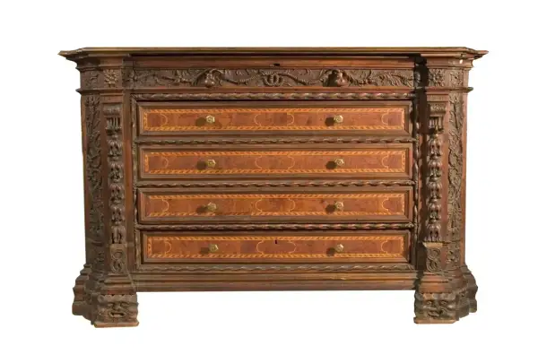 Antico canterano intarsiato con decorazioni scultoree, un vero pezzo d'antiquariato che evoca il suo significato storico.